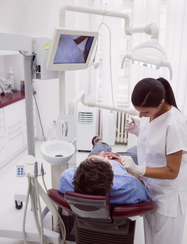 Female dentist examining patient in dental clinic